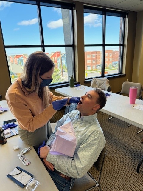 student applies fluoride varnish